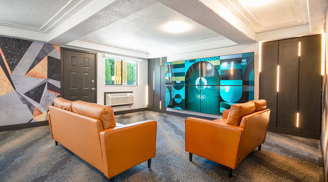 Lounge at the Coast Courtenay Hotel featuring two couches and a TV screen