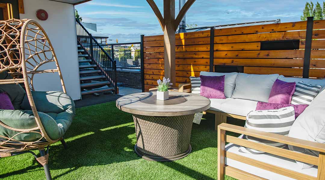 Outdoor seating area at the Coast Courtenay Hotel featuring couches and a firepit