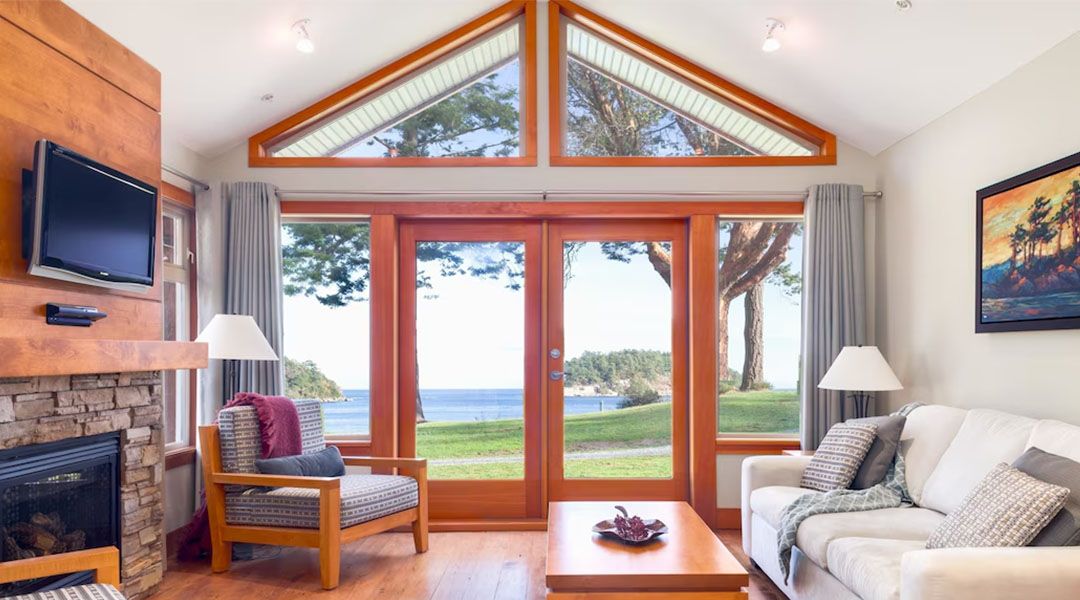 Bright and spacious resort interior with large timber-framed windows, comfortable seating, natural wood accents, and views of the surrounding landscape.