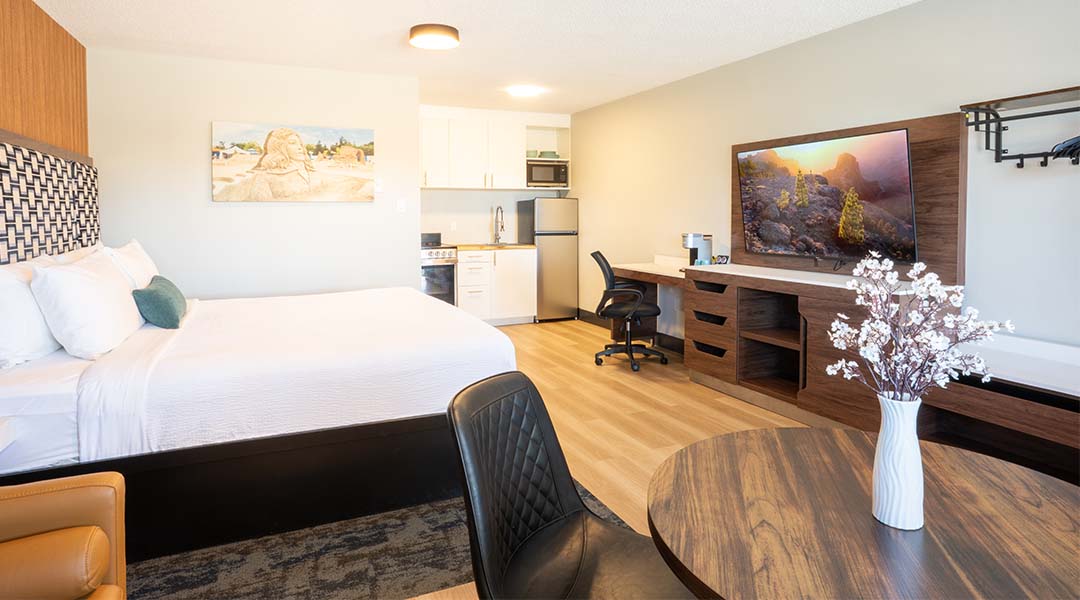 Room at Tide’s Out with bed, tv, kitchenette, and sitting area
