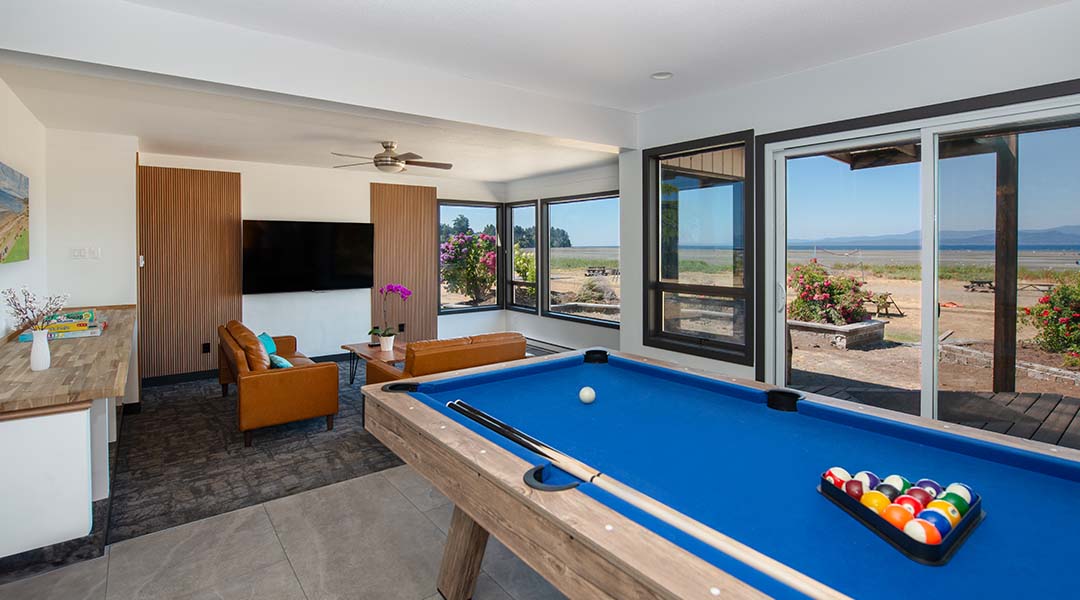 Lounge at Sea Edge Hotel with a pool table, two couches, and direct access to the beach.