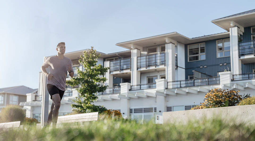 Guest jogging on grassy area in front of Steveston Waterfront Hotel