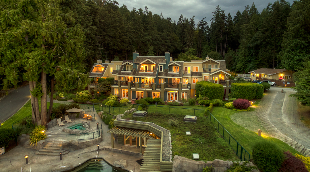 Aerial view of Poets Cove Resort and Spa on Pender Island at dusk with the lush green forest behind