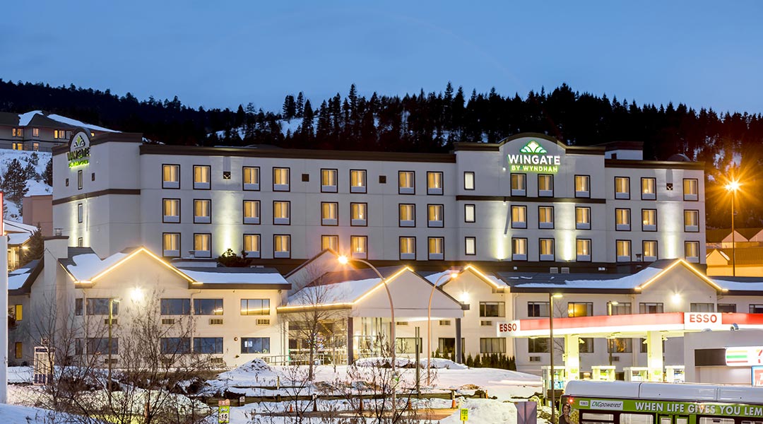 The exterior building at dusk of the Wingate by Wyndham Kamloops in the winter