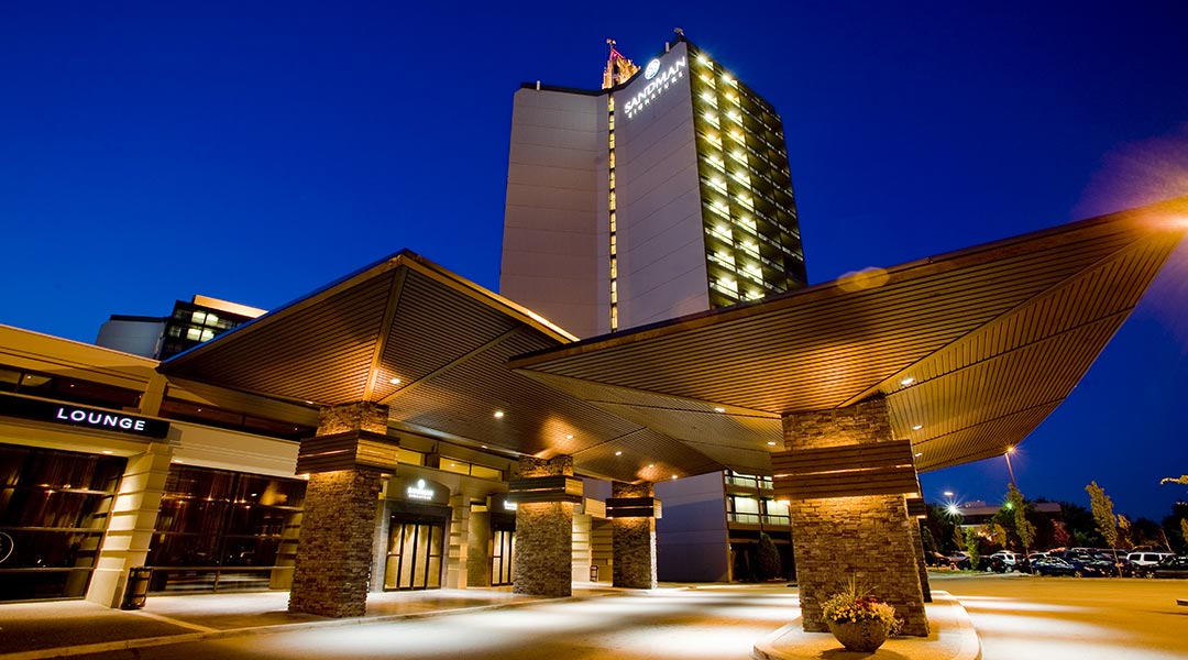 The exterior building and entrance of the Sandman Signature Vancouver Airport Hotel and Resort at night in Richmond