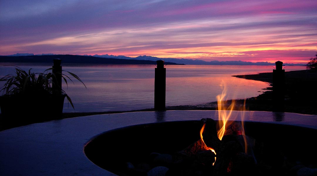 Firepit with an oceanview at dusk at the Beach Gardens Resort and Marina in Powell River on the Sunshine Coast