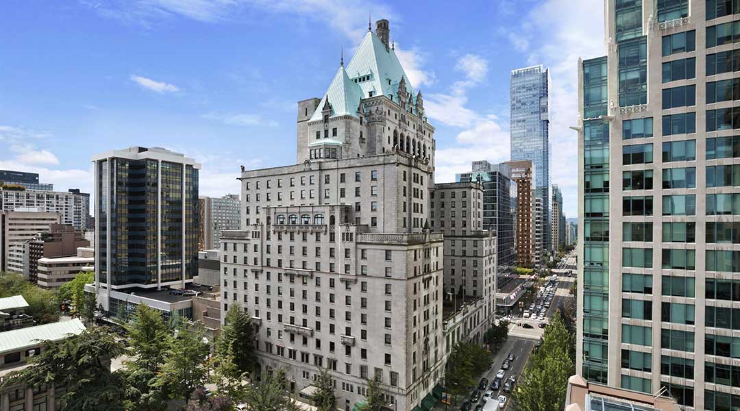 The exterior building of the Fairmont Hotel Vancouver and surrounding skyscrapers in downtown Vancouver