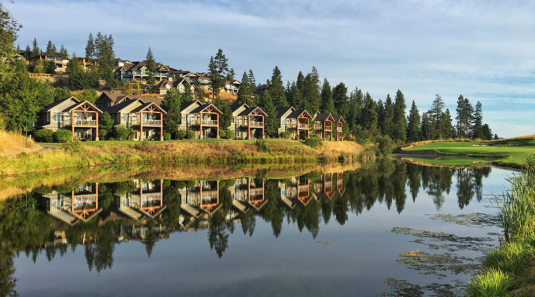 Predator Ridge villas and cottages across a still pond at Predator Ridge Resort in Vernon BC