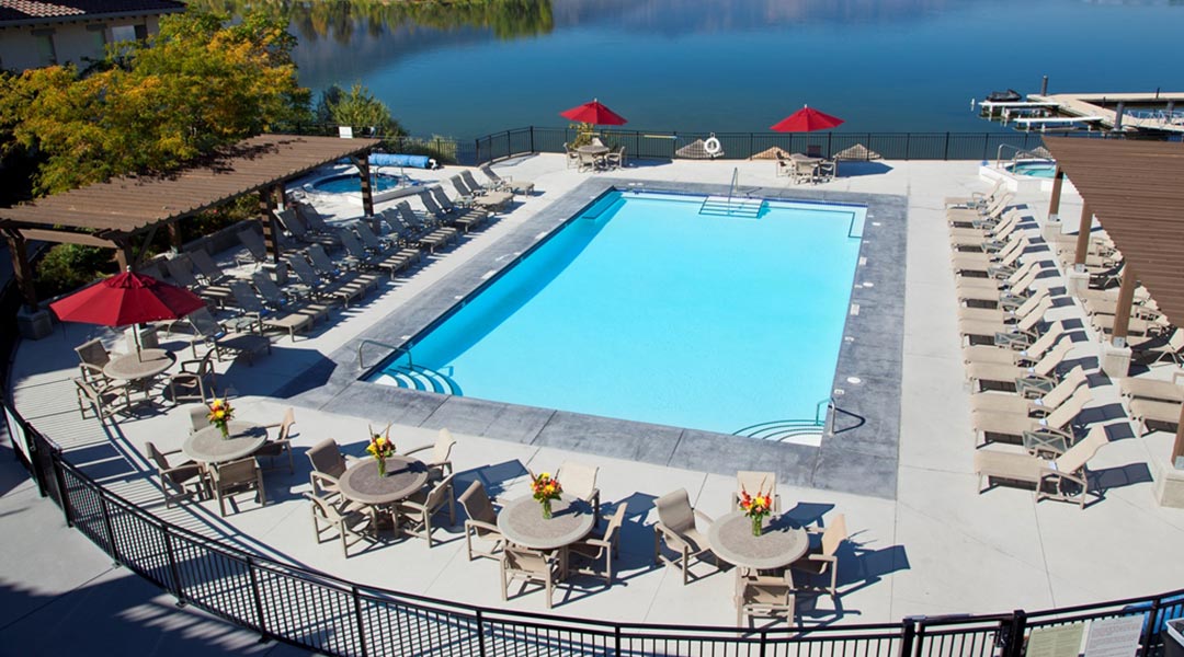 Aerial view of pool and lounge chairs at Walnut Beach Resort with lake beside in Osoyoos Okanagan