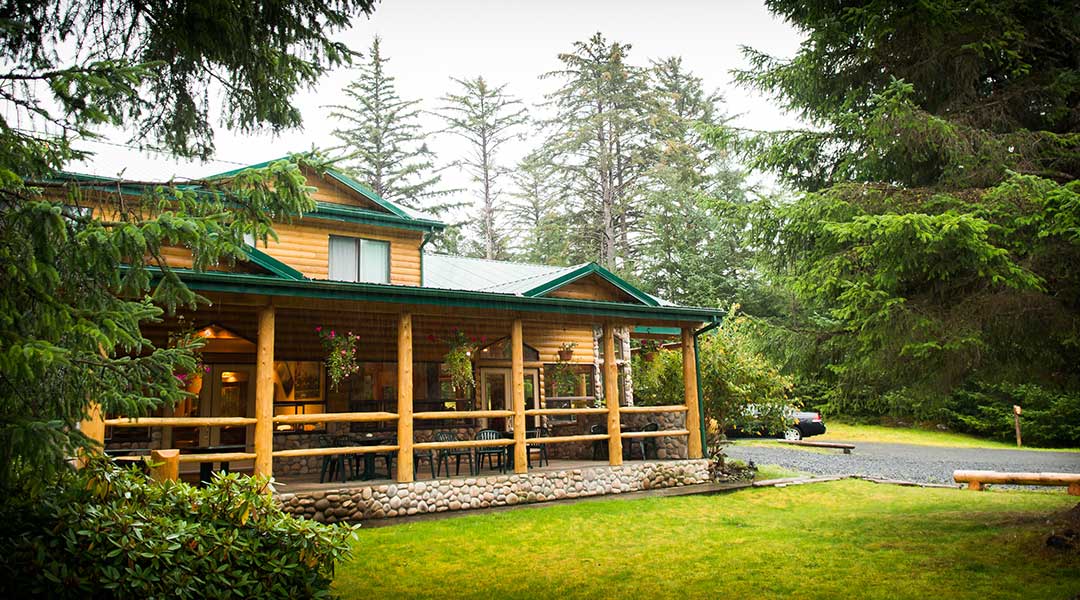 The exterior entrance and parking lot of the Haida House at Tlall Bed and Breakfast in Haida Gwaii