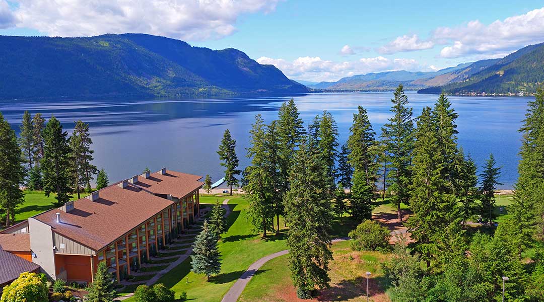 Aerial view of Quaaout Lodge and Spa with lake and trees in Chase BC