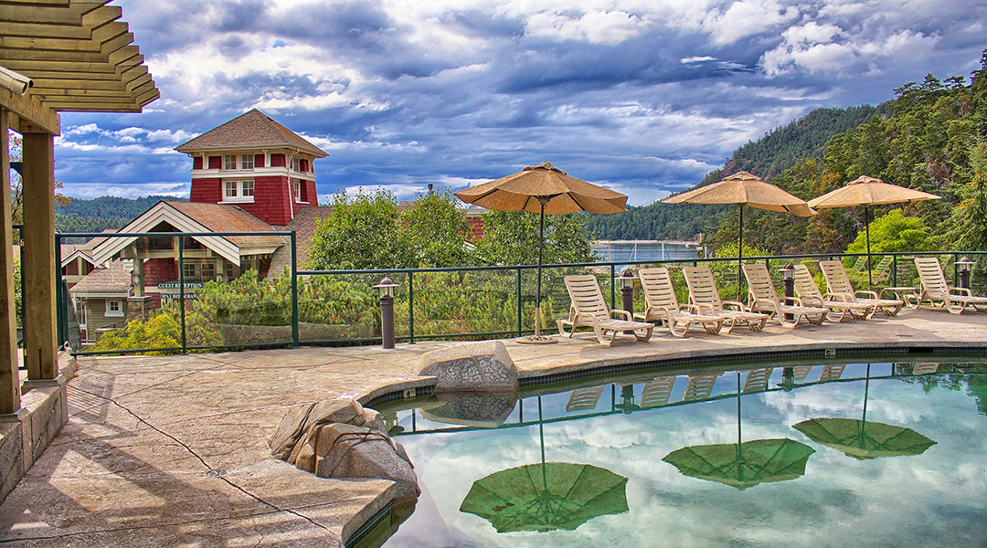 Upper outdoor pool with lounge chairs and umbrellas at Poets Cove Resort and Spa on Pender Island