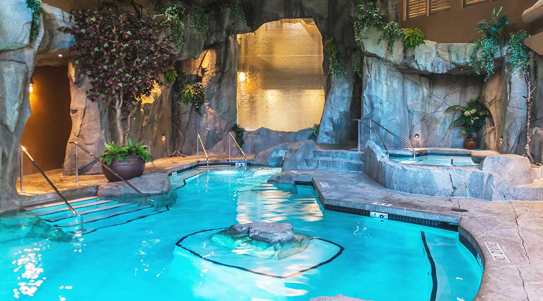 Indoor pool with hot tub and grotto at Tigh Na Mara Resort and Spa in Parksville