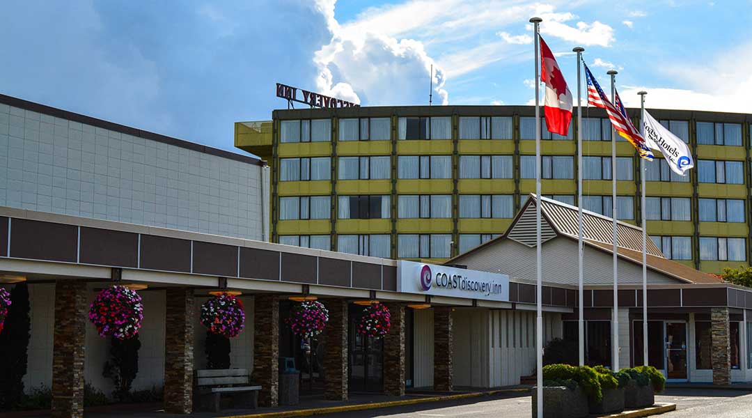 The exterior entrance and flag poles of the Coast Discovery Inn and Marina in Campbell River