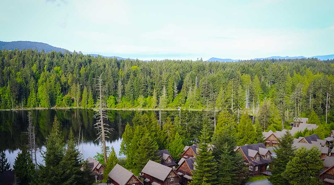 Aerial view of the cottages from Cottages on Salt Spring Island around a lake and forested trees