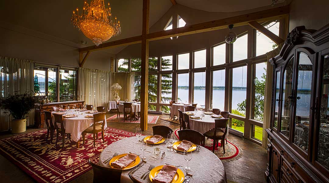 The dining room with many tables next to an ocean view at the Eagles Nest Resort in Anahim Lake Northern BC