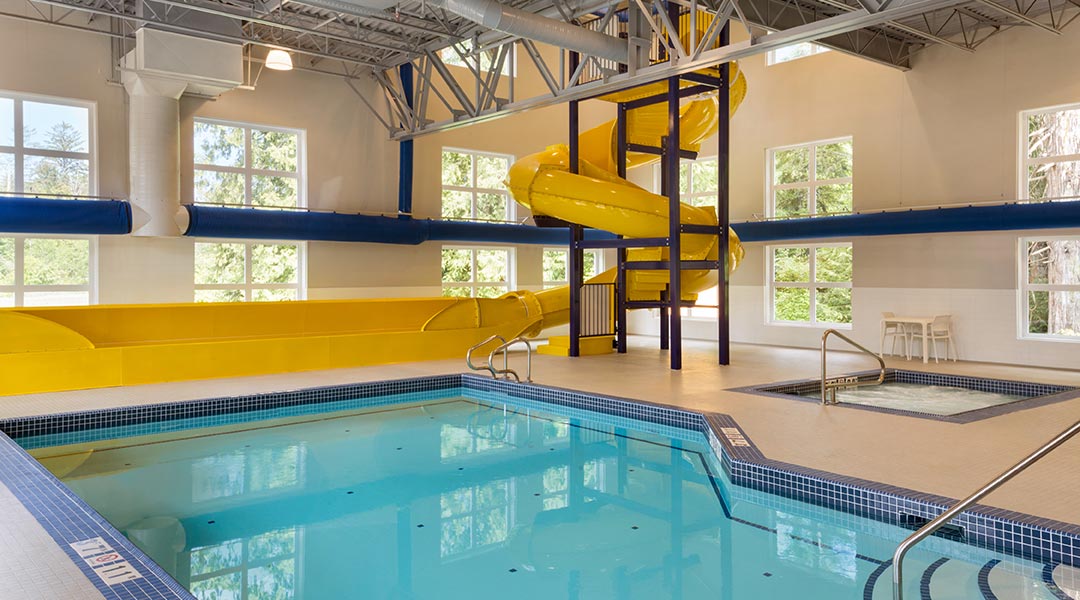 The indoor swimming pool and slide at the Microtel Inn and Suites by Wyndham Ladysmith Oyster Bay