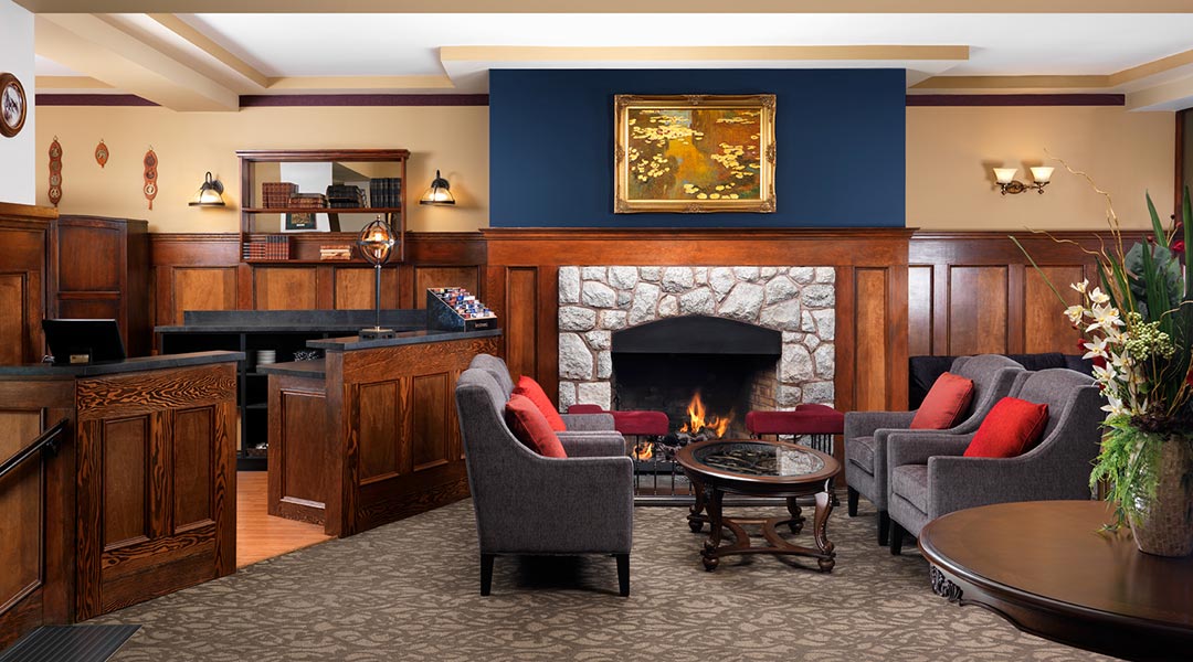 The interior lobby and seating area with a fireplace at the Huntingdon Manor in Victoria