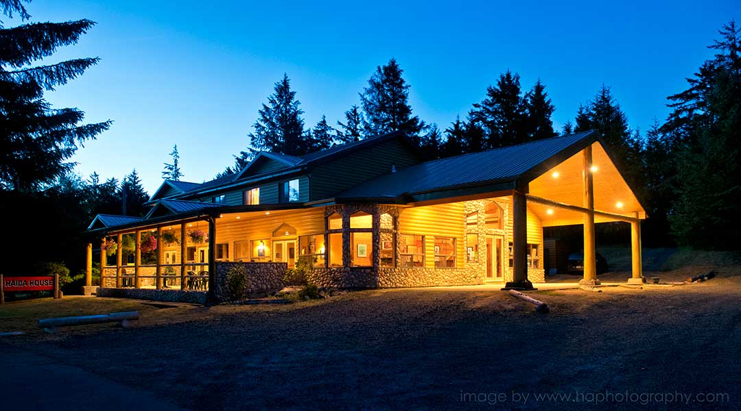 The exterior entrance and parking lot of the Haida House at Tlall Bed and Breakfast in Haida Gwaii at night