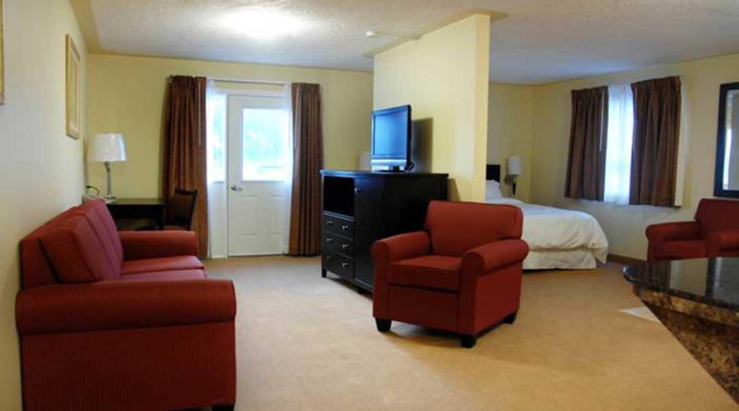 Sitting area with television and wall separating bed in the VIP suite at Sunshine Inn in Smithers BC